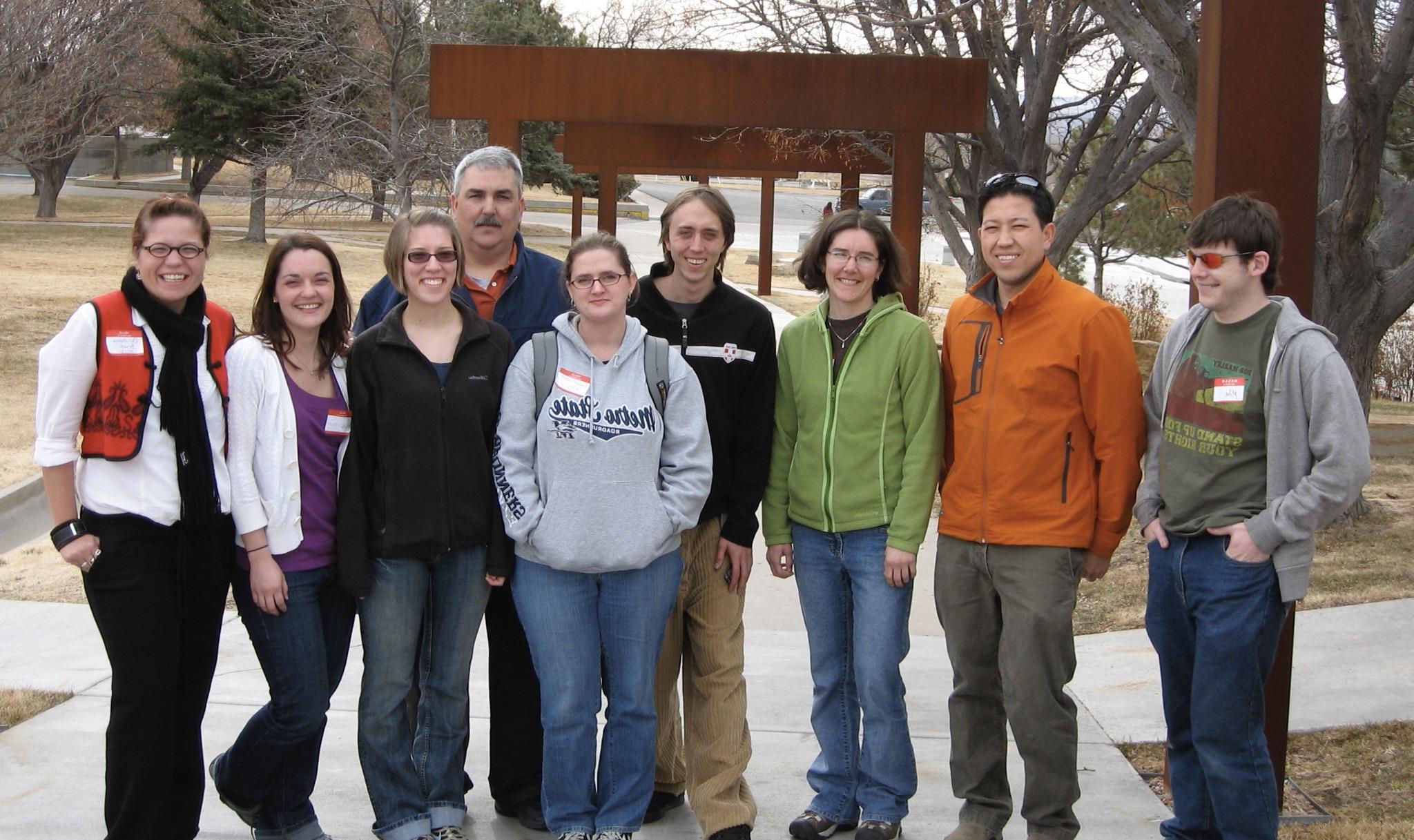 Group of students and professors standing and smiling outside